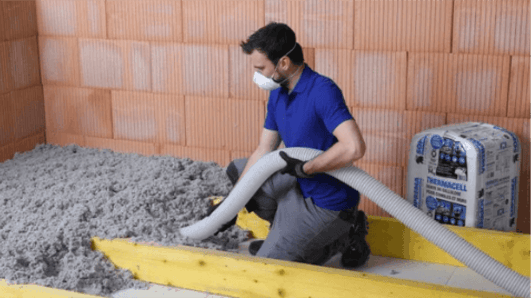 Un homme met en œuvre de la ouate de cellulose