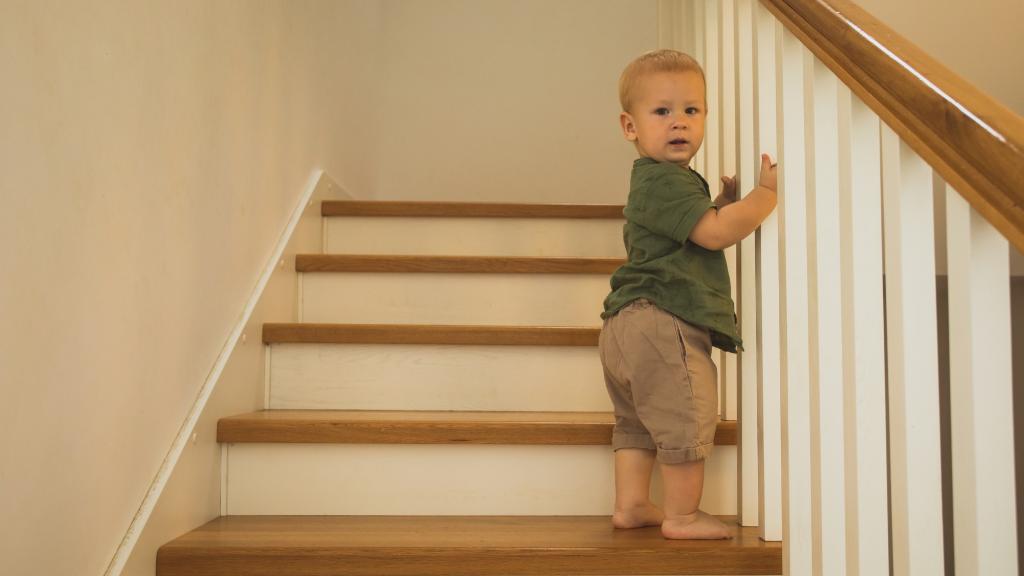 Enfant qui monte des escaliers en bois