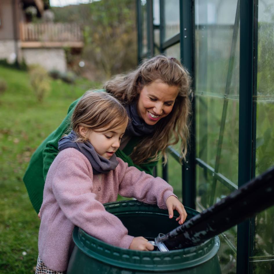 Mère et fille qui récupèrent l'eau de pluie