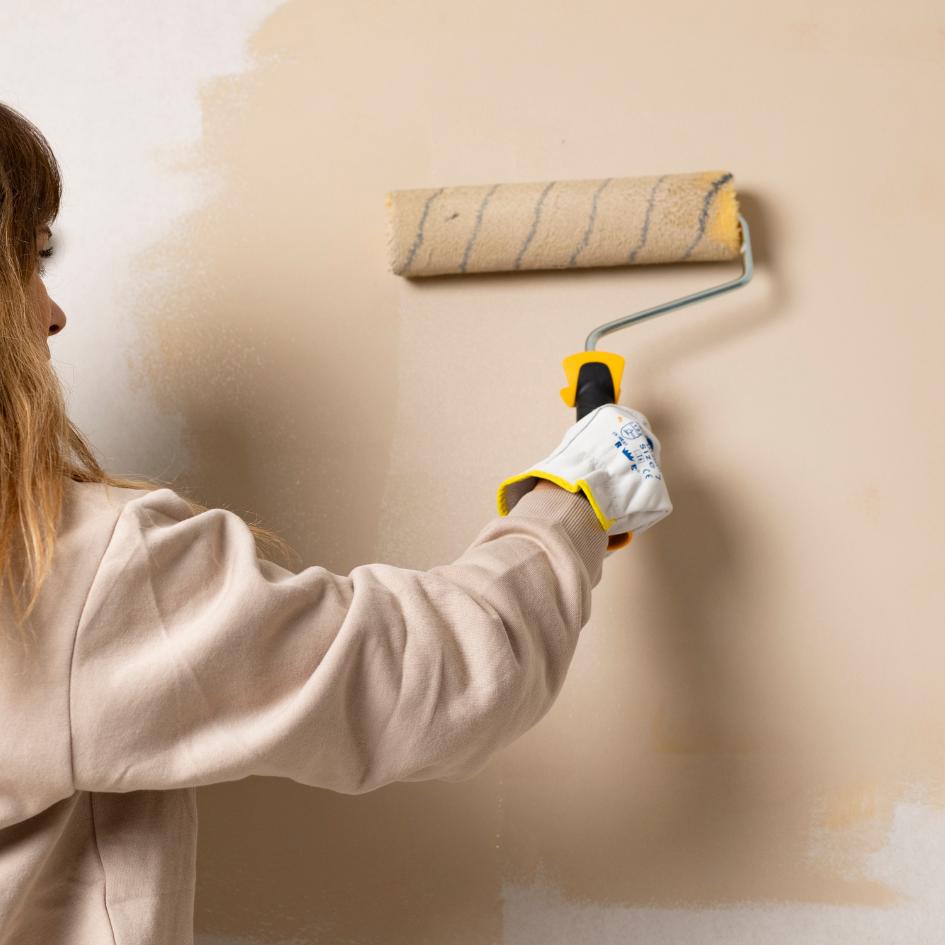 Femme qui peint un mur en beige