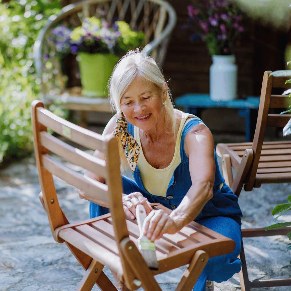 Femme qui met une résine sur une chaise en bois