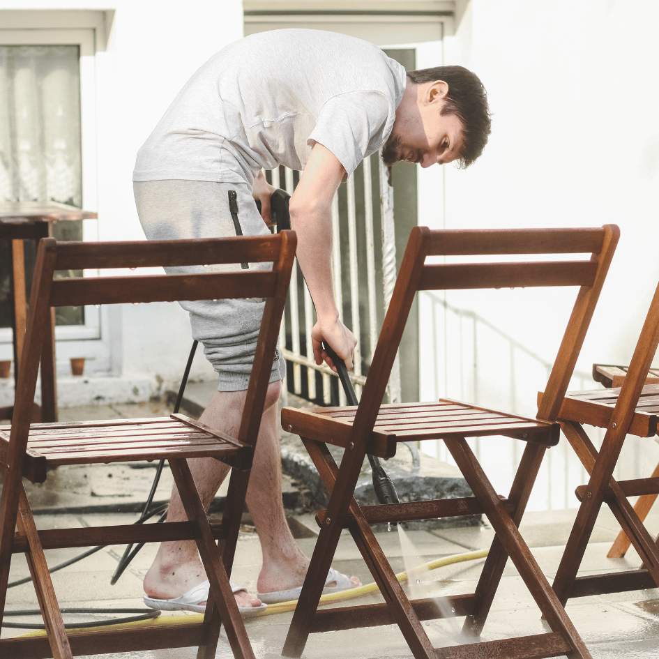 Homme qui nettoie des chaises en bois