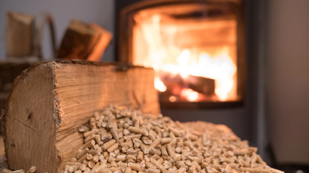 Pellets et bûche de bois devant un poêle à pellets