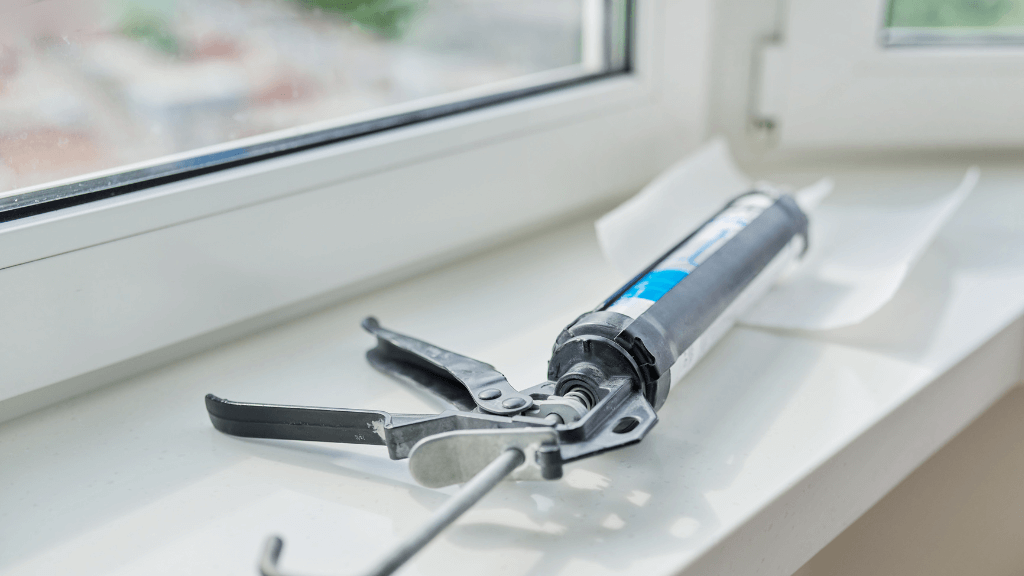 Un pistolet avec du joint silicone pour paroi de douche