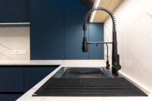 Cuisine bleue avec un évier de cuisine noir 