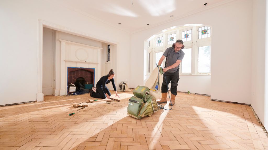 Homme qui ponce un parquet