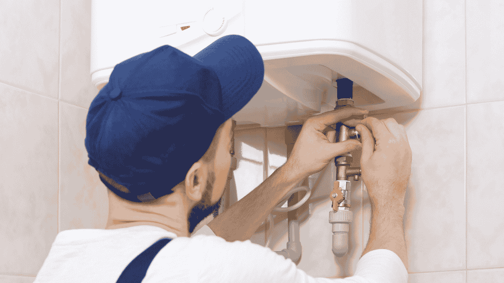 Plombier qui répare un chauffe-eau
