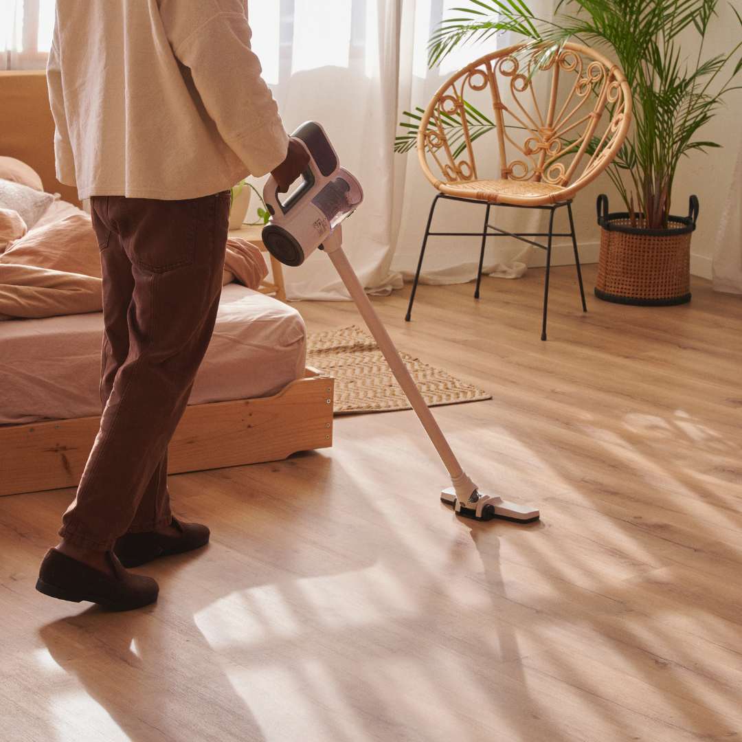Homme qui aspire un parquet beige